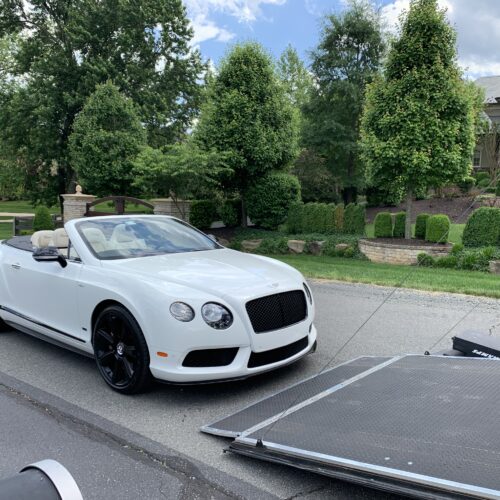 A white color Bentley with open roof