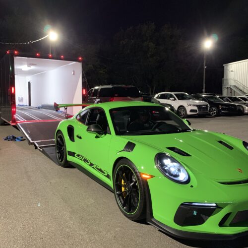 A lime green color sports car coming out of a truck